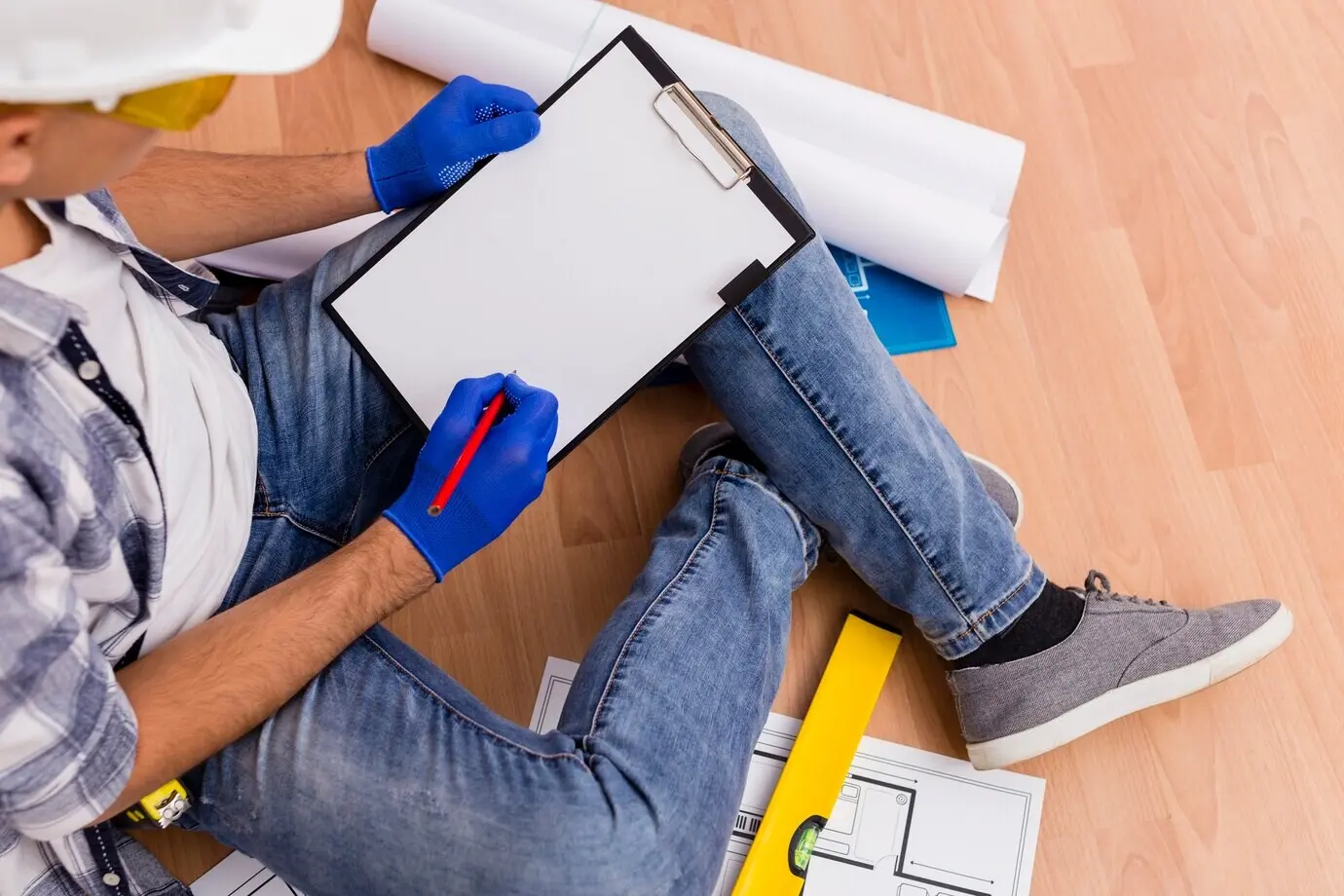 Ansicht von oben auf einen Mann, der ein Klemmbrett hält.