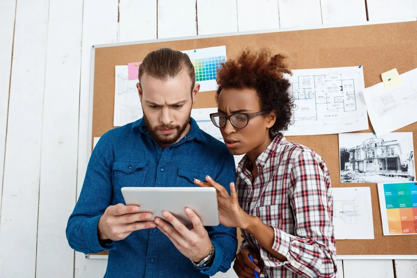 Kollegen betrachten ein Tablet und diskutieren neue Ideen.